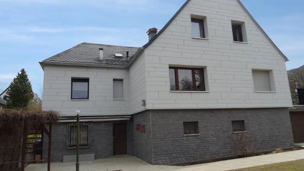 Fassadensanierung einer Putzfassade mit PREFA Sidings.X horizontal verlegt in Weiß mit grauem Klinker.