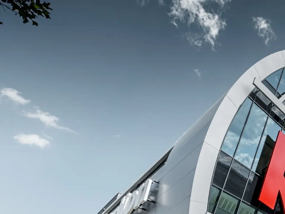 L’entrée de l’Allianz Stadion avec le grand logo du SK Rapid de Vienne ; le tube avec la grande façade vitrée est recouvert du panneau composite en aluminium PREFA couleur argent métallisé.