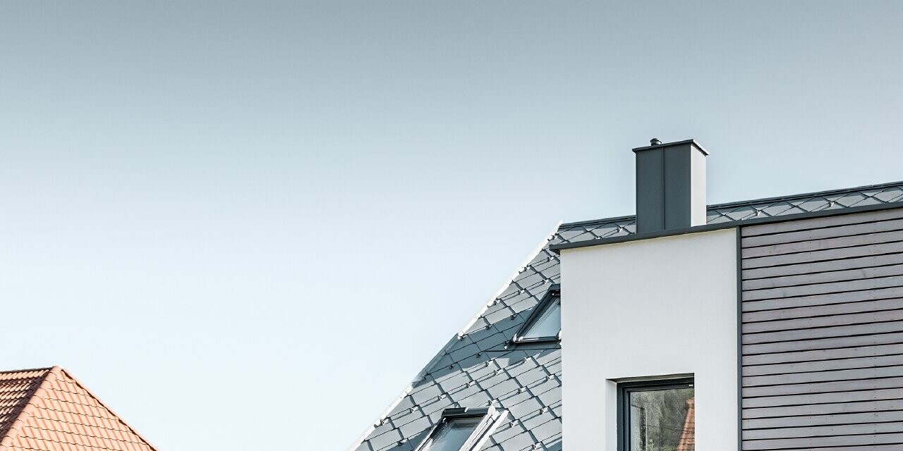 La maison individuelle avec toit à deux pans à Leonding a été entièrement rénovée. La surface de toit a été recouverte de losanges de toiture 44 × 44 PREFA couleur gris souris avec arrêts neige. Le choix s’est porté sur la gouttière suspendue de PREFA, également couleur gris souris. 