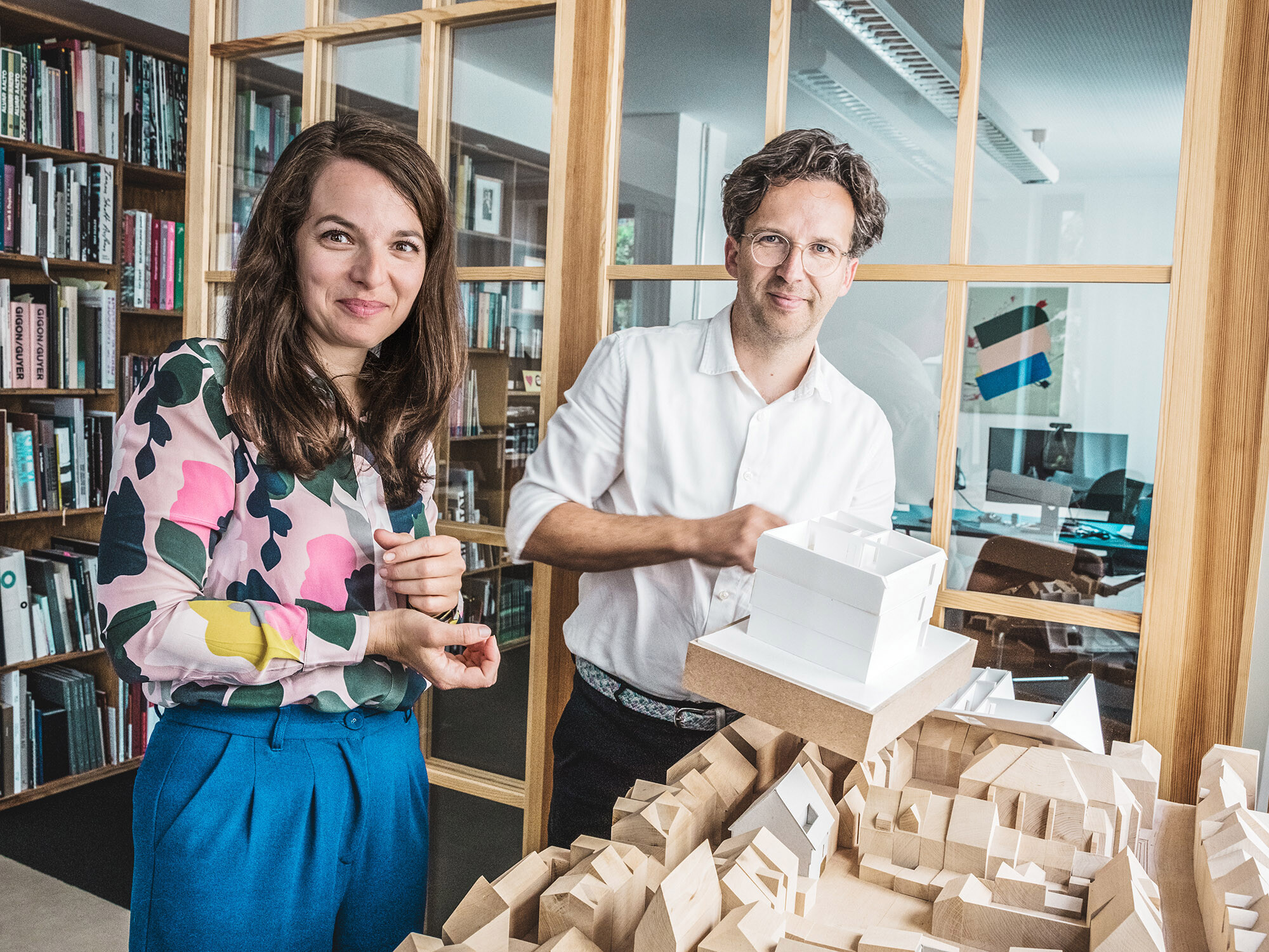 Portrait der Architekten Silvia Schellenberg-Thaut und Sebastian Thaut von Atelier ST mit Modellen in ihrem Büro.