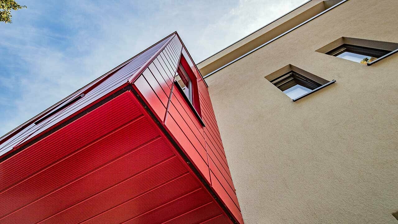 Bovindo con doghe PREFA rigate in rosso rubino in una moderna casa unifamiliare a Wernigerode, qui è fotografato l’intradosso del fabbricato aggiunto aggettante.