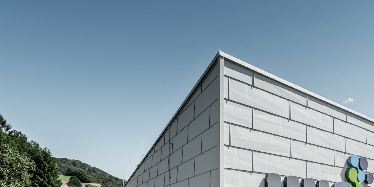 Bâtiment de société moderne à Ybbsitz avec toit plat et façade en aluminium ; la façade a été habillée avec les panneaux de façade FX.12 PREFA couleur blanc PREFA.