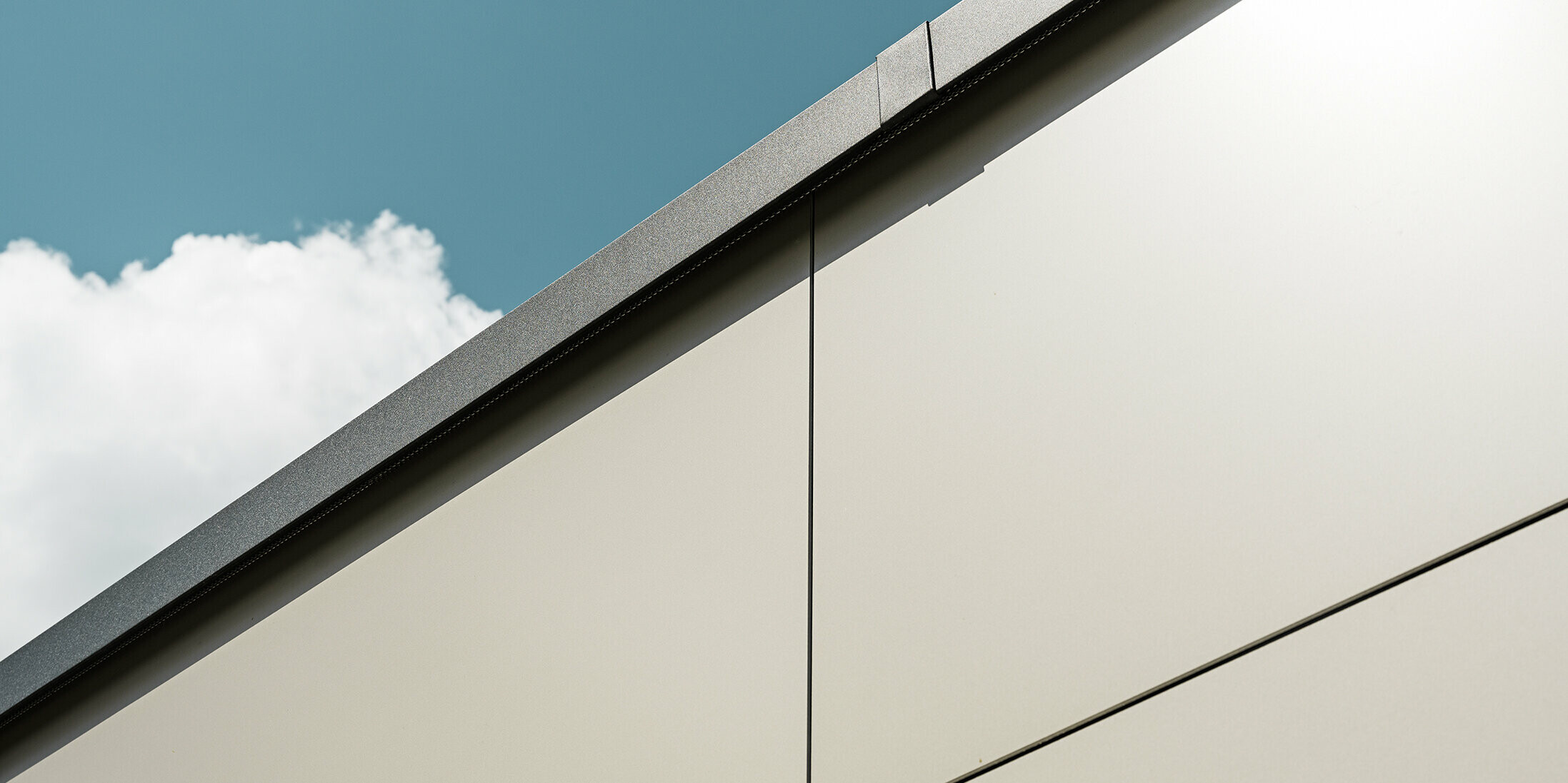 Nahaufnahme einer Garagenverkleidung mit PREFA Aluminium Verbundplatten in edlem Bronze. Die Perspektive zeigt die hohe Verarbeitungsqualität.