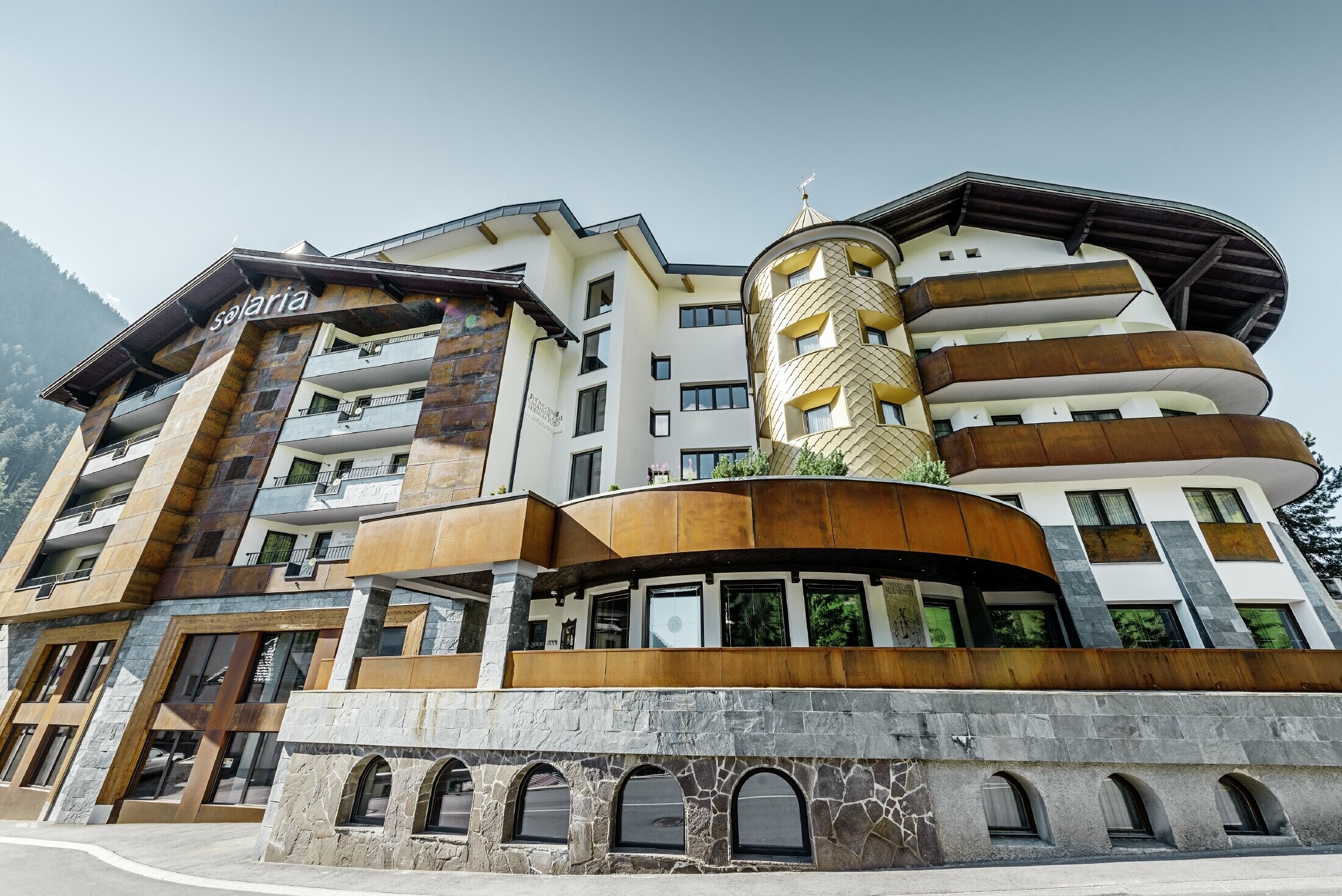 hotel tradizionale a Ischgl con balconi in legno e facciata in legno e una torre in scaglie PREFA in oro