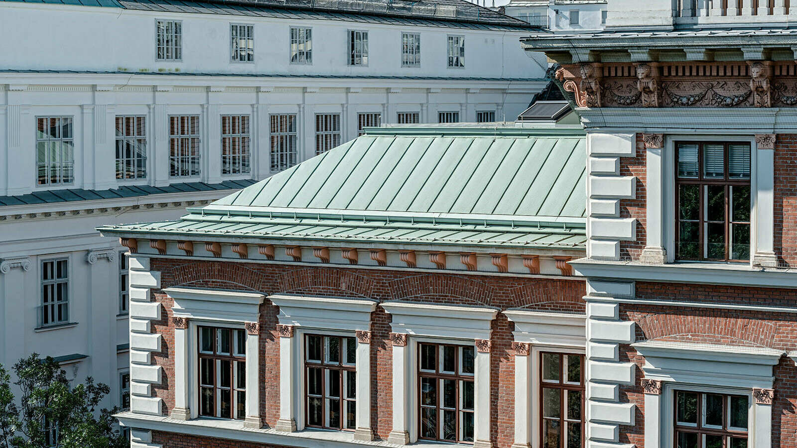 Eine Detailansicht des Dachsystem Prefalz von PREFA in der Farbe Opalgrün der Evangelischen Volkschule am Wiener Karlsplatz.