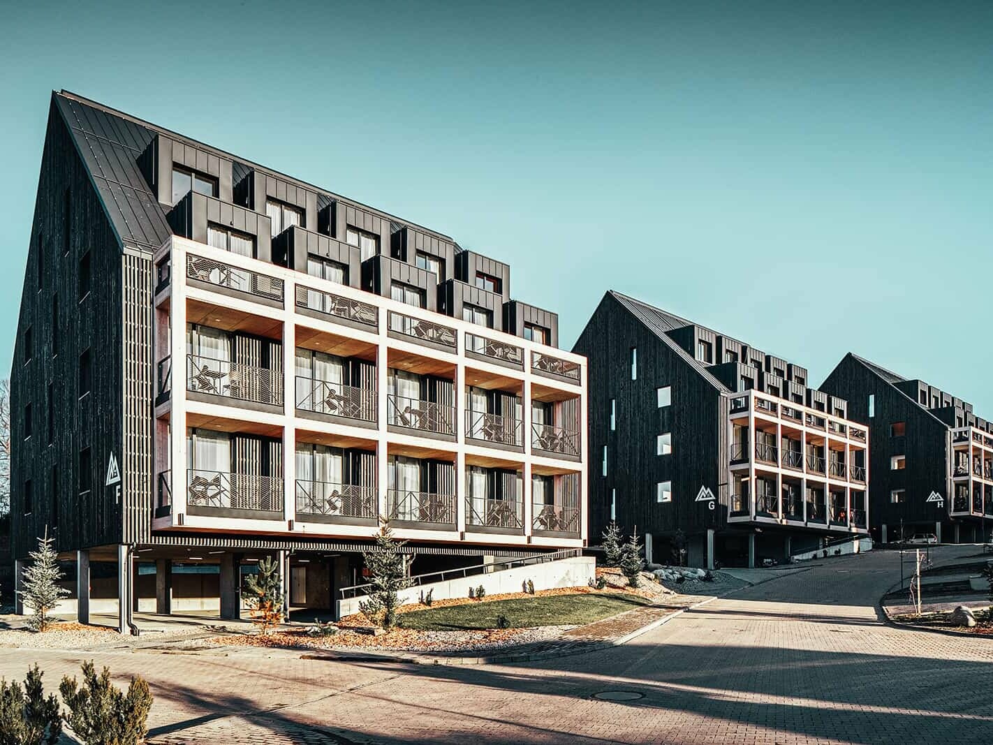 Das Bild zeigt die perfekte Ergänzung von Aluminium und Holz am neu errichteten Demänova Resort im Sonnenschein. Verwendet wurde Prefalz in der Farbe Anthrazit.