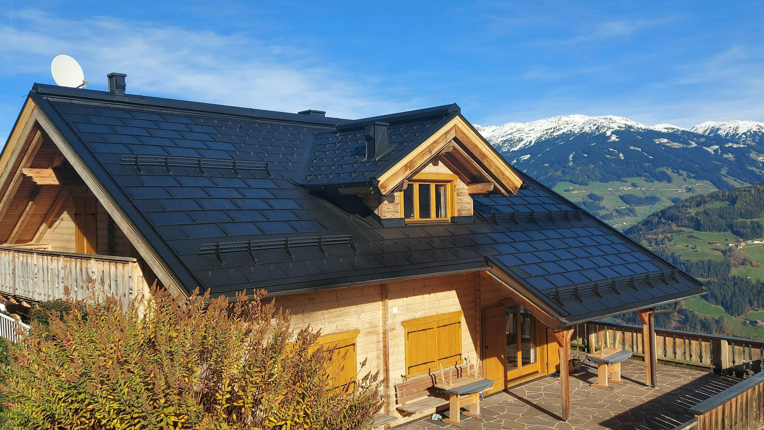 Rénovation d'une maison individuelle à Hippach (Tyrol) avec le panneau solaire de toiture PREFA de petite taille en P.10 noir, combiné avec le panneau de toiture PREFA R.16.