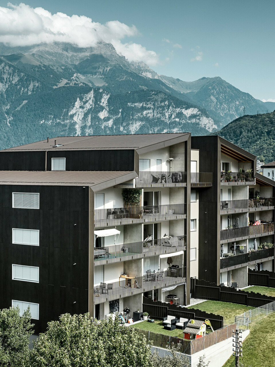 La façade du complexe résidentiel Les Dailles a été largement recouverte de l'impressionnant profil triangle PREFA en bronze. Le toit du bâtiment a été recouvert de PREFALZ en bronze.