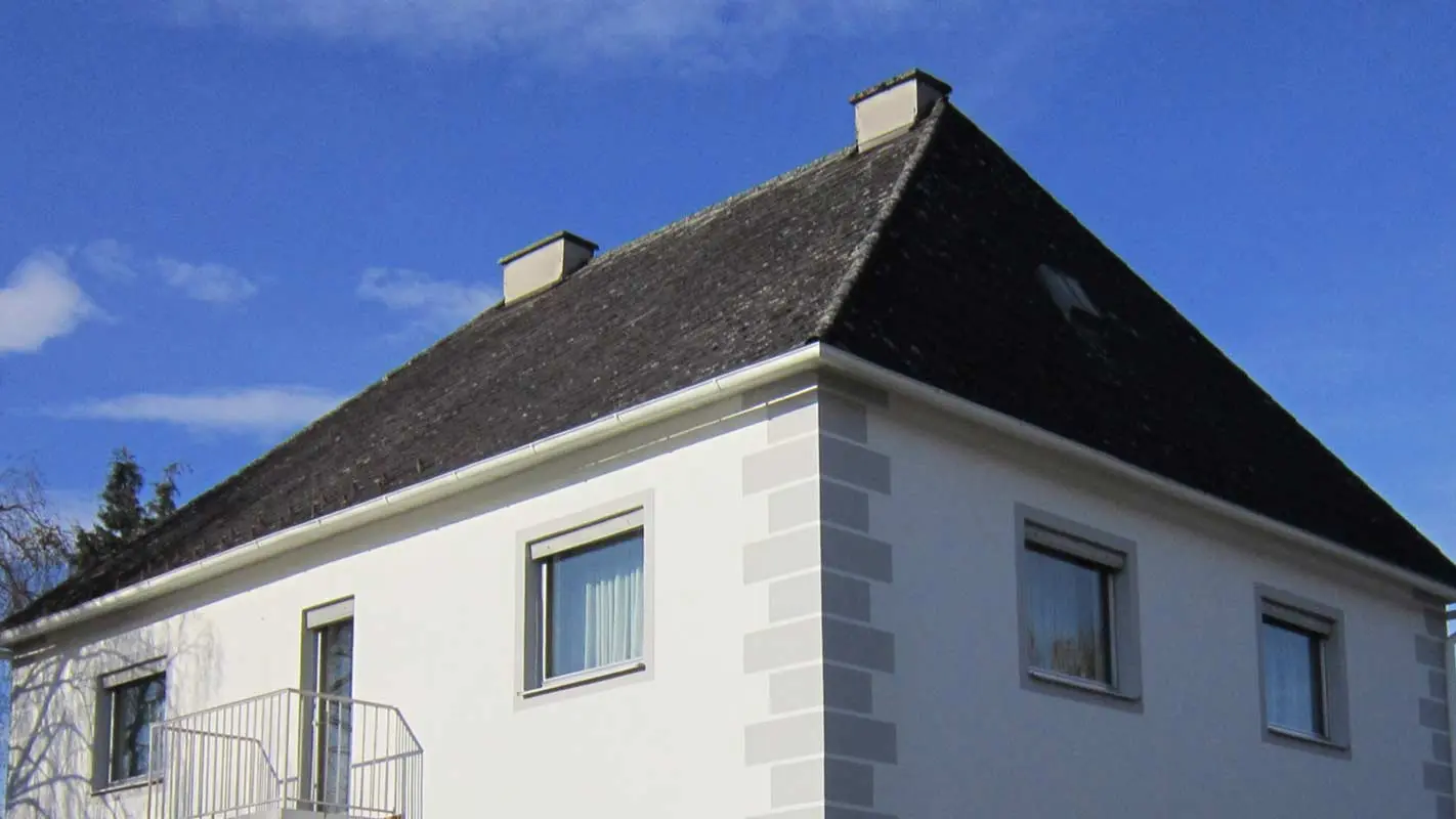Casa con tetto a padiglione prima della ristrutturazione del tetto con Prefalz e tegole PREFA in Austria