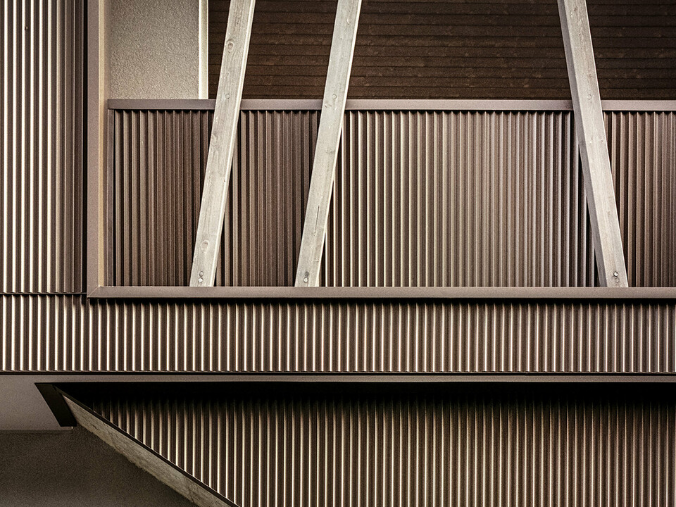 Eine Nahaufnahme der gezackten Aluminiumfassade mit den schräg gestellten Holzbalken der Villa 2B in Morbegno, saniert vom Architekten Massimo Mescia vom Büro altrostudio architetti.