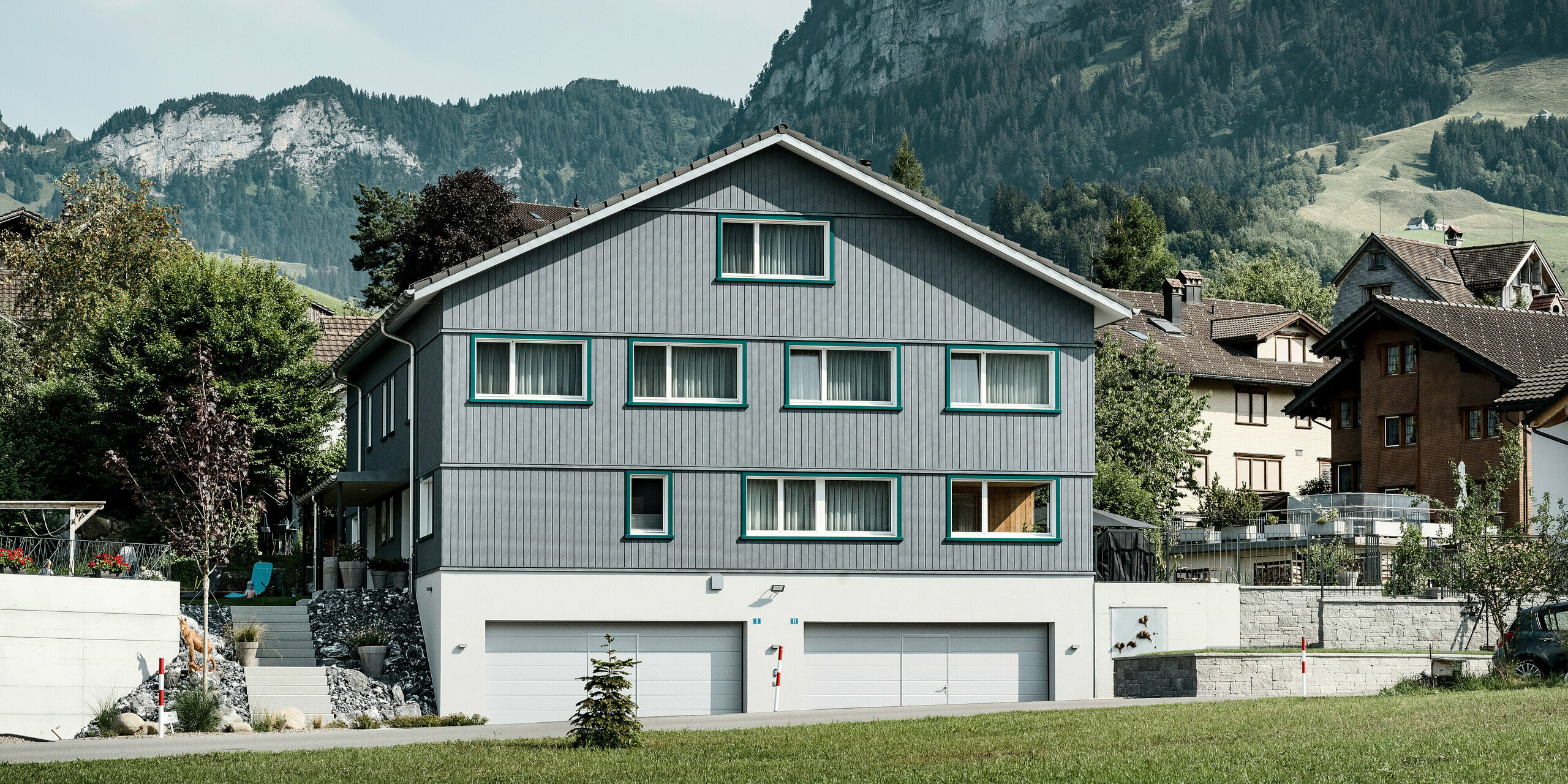 Sidings PREFA en gris pierre P.10 et blanc Prefa P.10 sur les façades de deux immeubles d'habitation voisins à Weissbad, en Suisse.