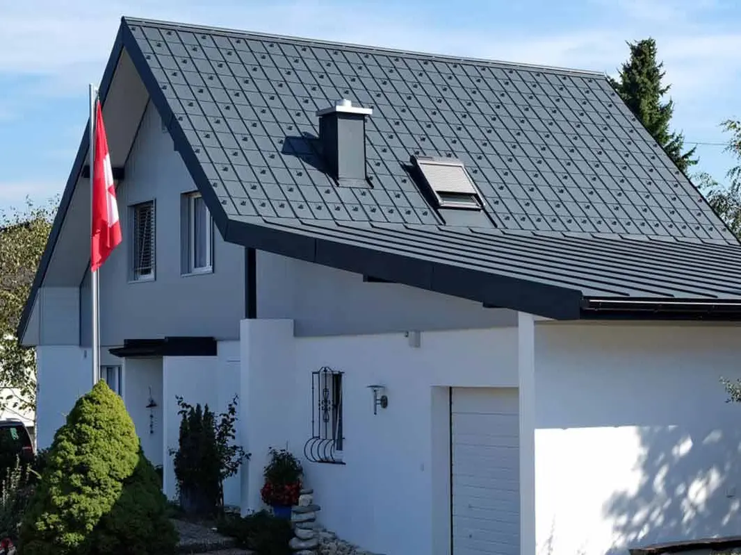 Maison avec garage après la rénovation de toiture à l’aide de tuiles PREFA couleur anthracite