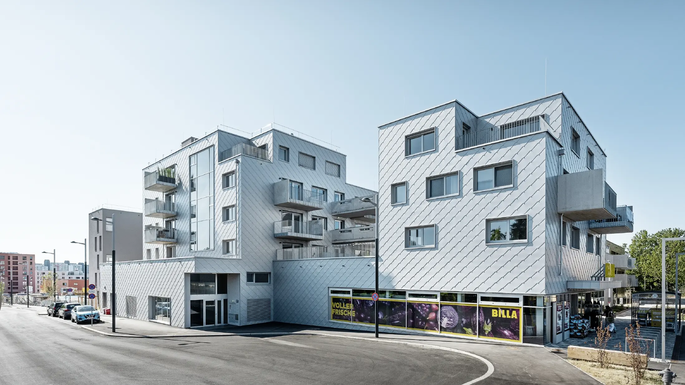 Edifici residenziali con tetto piano e rivestimento a scaglie sulla facciata con la scaglia PREFA 44 × 44 in silver metallizzato