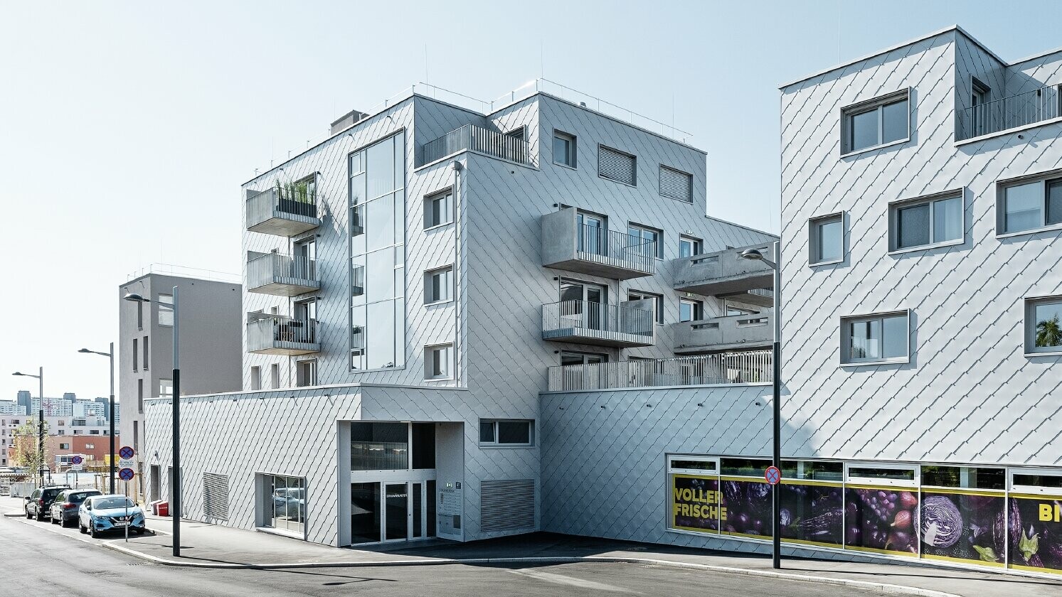 Edifici residenziali con tetto piano e rivestimento a scaglie sulla facciata con la scaglia PREFA 44 × 44 in silver metallizzato