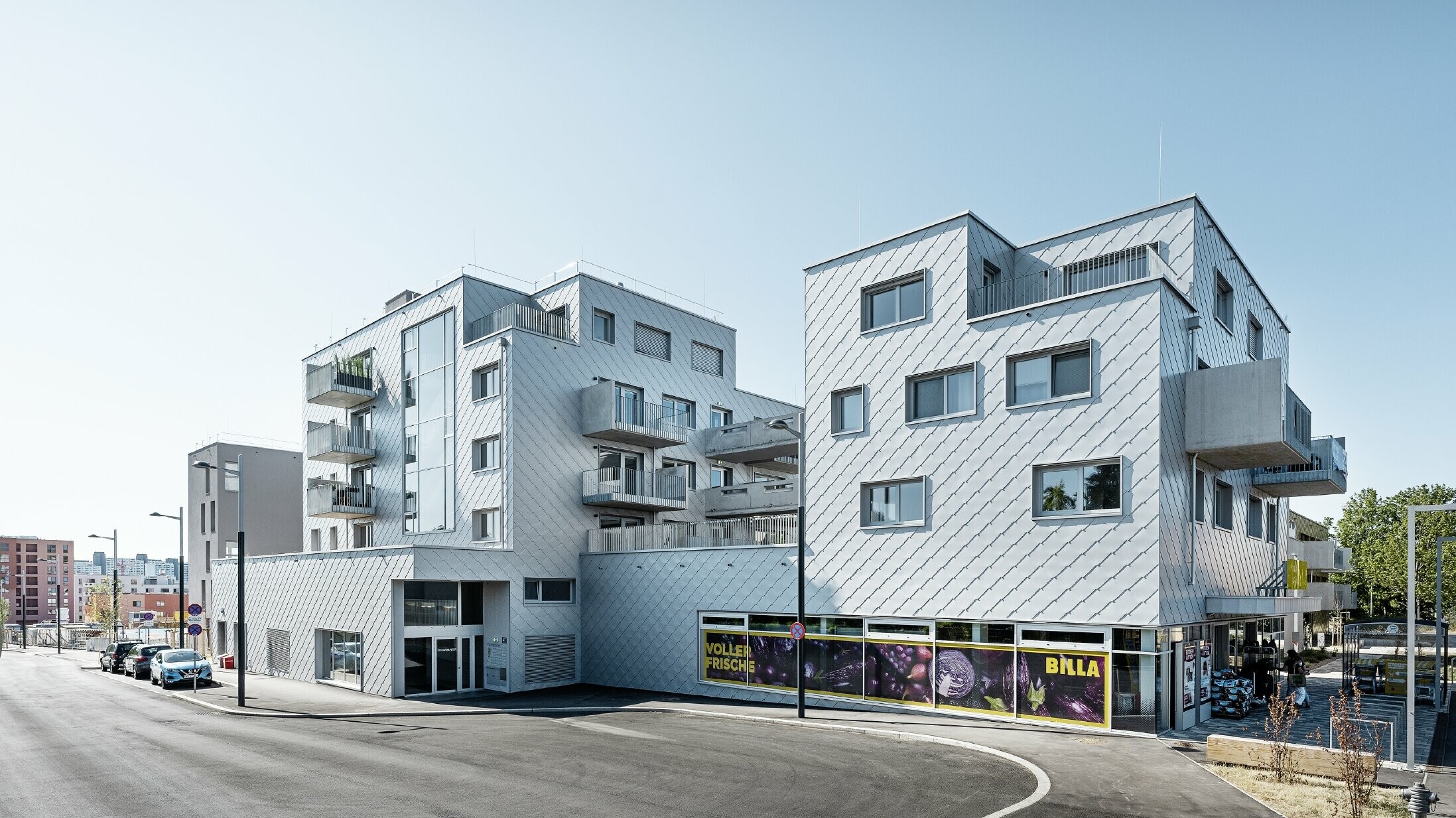 Wohnhausanlagen mit Flachdach und Rautenverkleidung an der Fassade mit der PREFA Wandraute 44 × 44 in Silbermetallic