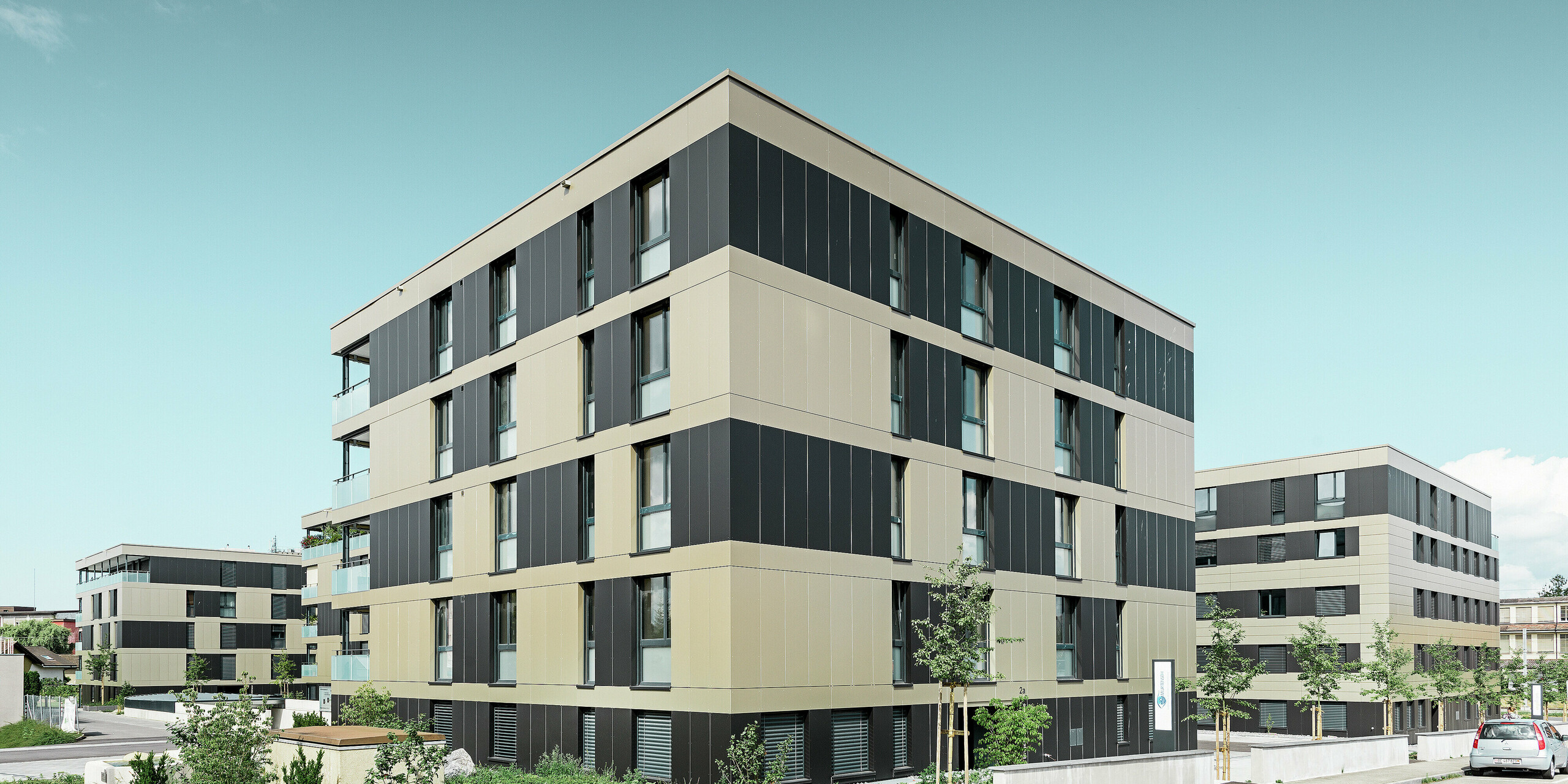 Complexe résidentiel aux immeubles cubiques — Façades en aluminium PREFA de couleur bronze avec des éléments gris noir
