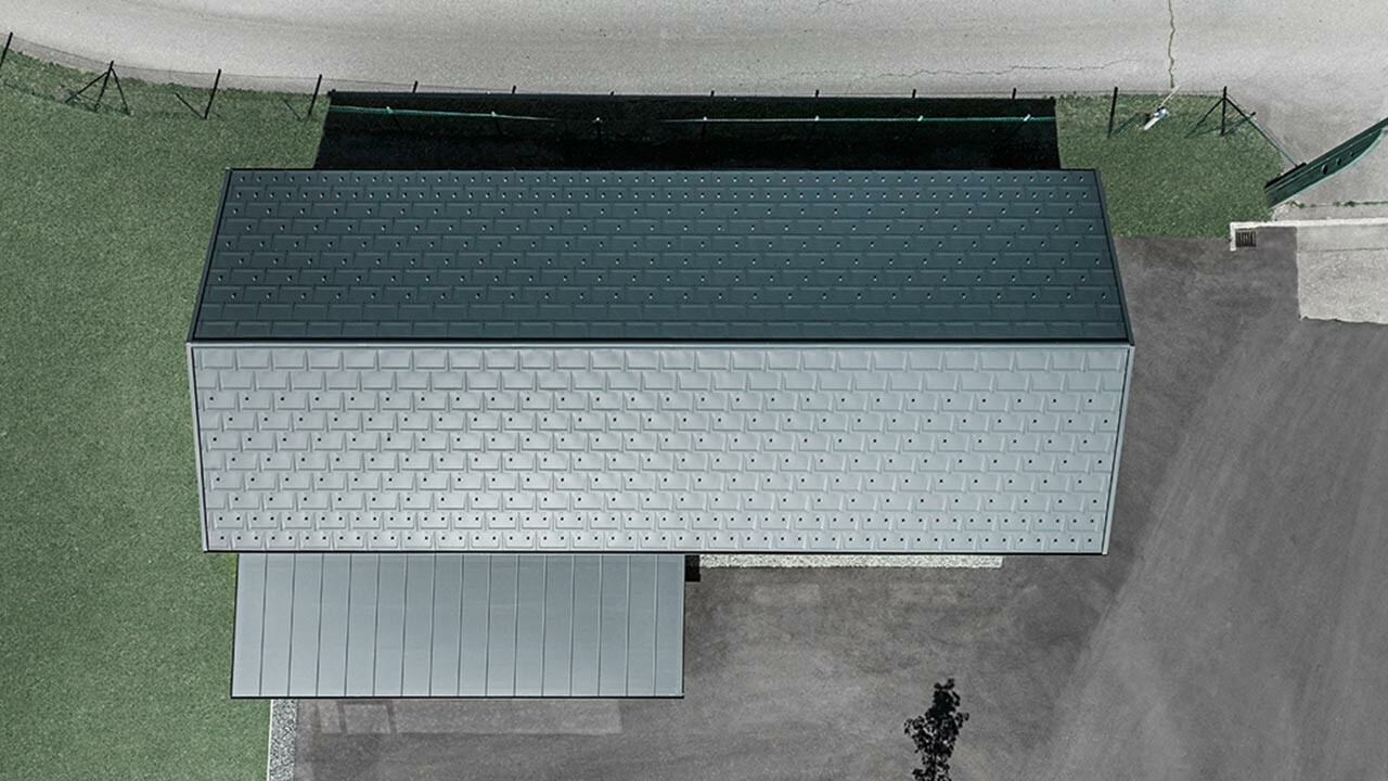 Vogelperspektive, aufgenommen mit einer Drohne, vom neuen Bürohaus von Holzbau Faltheiner, das Dach ist eingedeckt mit der PREFA Dachplatte R.16 in Anthrazit