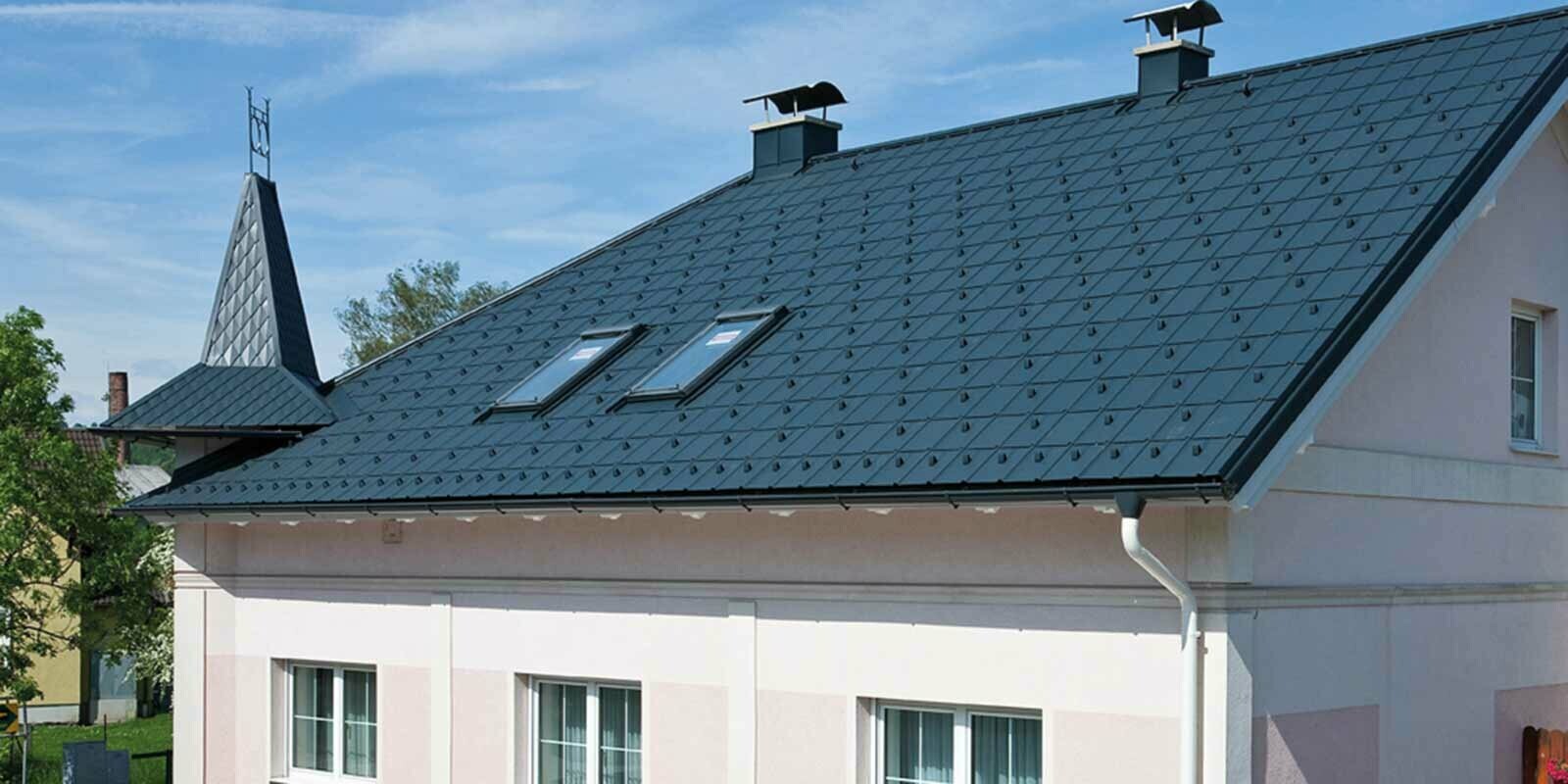 Maison après la rénovation de toiture à l’aide de tuiles PREFA, en Autriche. Auparavant fibrociment Eternit avec tourelle et façade rose