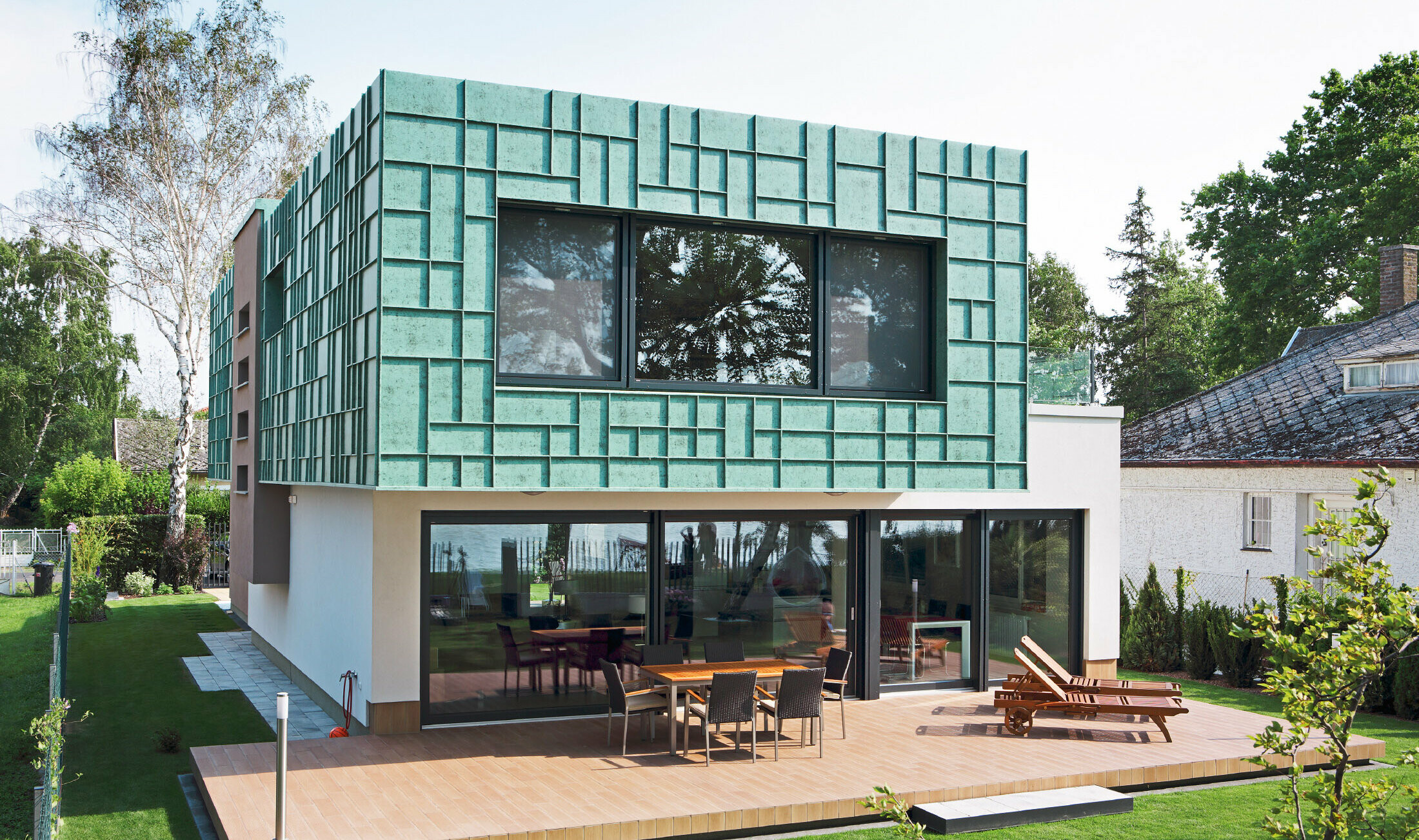 Modernes Einfamilienhaus mit sturmsicherer Fassade, die mit PREFALZ in P.10 Patina Grün verkleidet wurde.