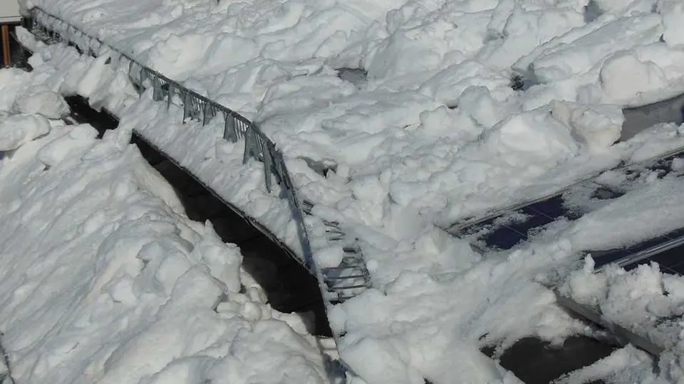 Dispositif de retenue de neige tordu par la neige, associé à une installation photovoltaïque