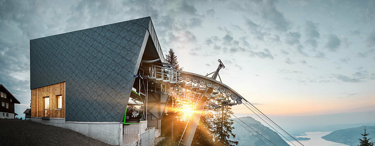 Le robuste scaglie a rombo PREFA in P.10 grigio pietra rivestono la facciata della funivia Kräbel-Rigi a Scheidegg, Svizzera