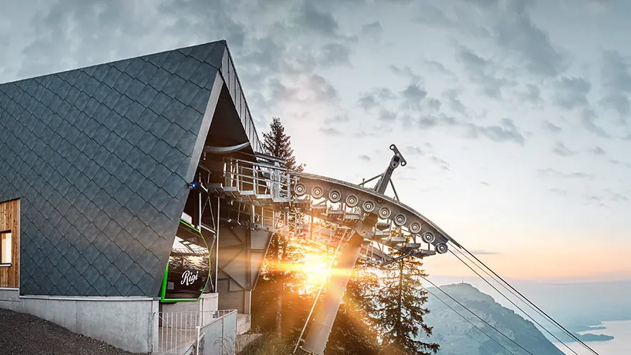 Les losanges de toiture PREFA robustes en P.10 gris pierre recouvrent la façade du téléphérique Kräbel-Rigi à Scheidegg, en Suisse.