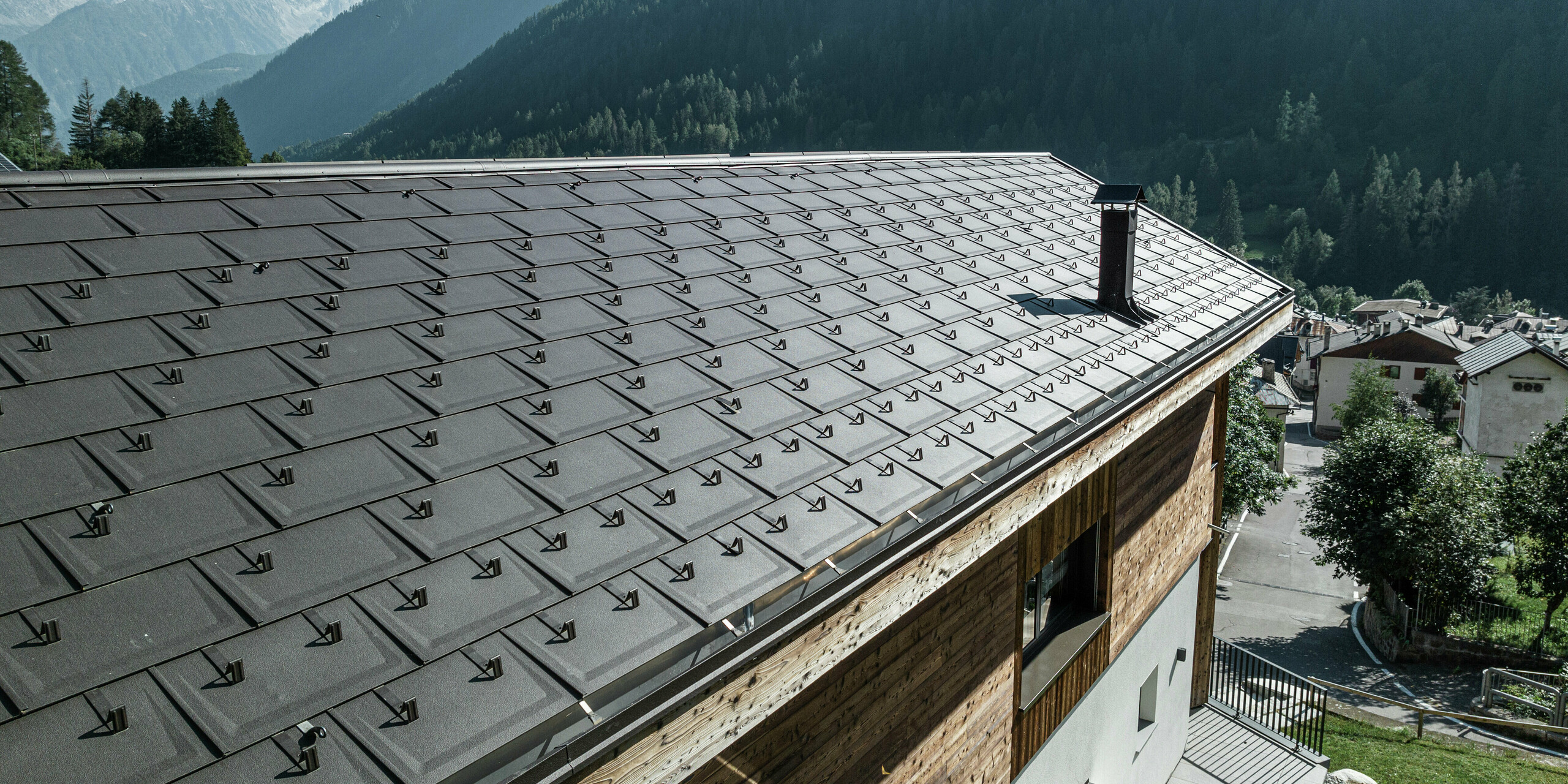 Gros plan sur les R.16 PREFA en P.10 brun qui confèrent à ce refuge de montagne à Cogolo, Val di Sol, un aspect élégant et offrent également une protection maximale contre les conditions météorologiques extrêmes. La toiture en aluminium durable avec pare-neige intégrés assure sécurité et stabilité aux hauteurs alpines. Une toiture esthétique et facile d'entretien pour des générations.