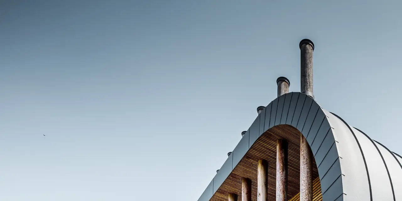 Facciata dalle linee curve nella casa unifamiliare Casa Giovannini rivestita con alluminio di PREFA - Prefalz in P.10 antracite.