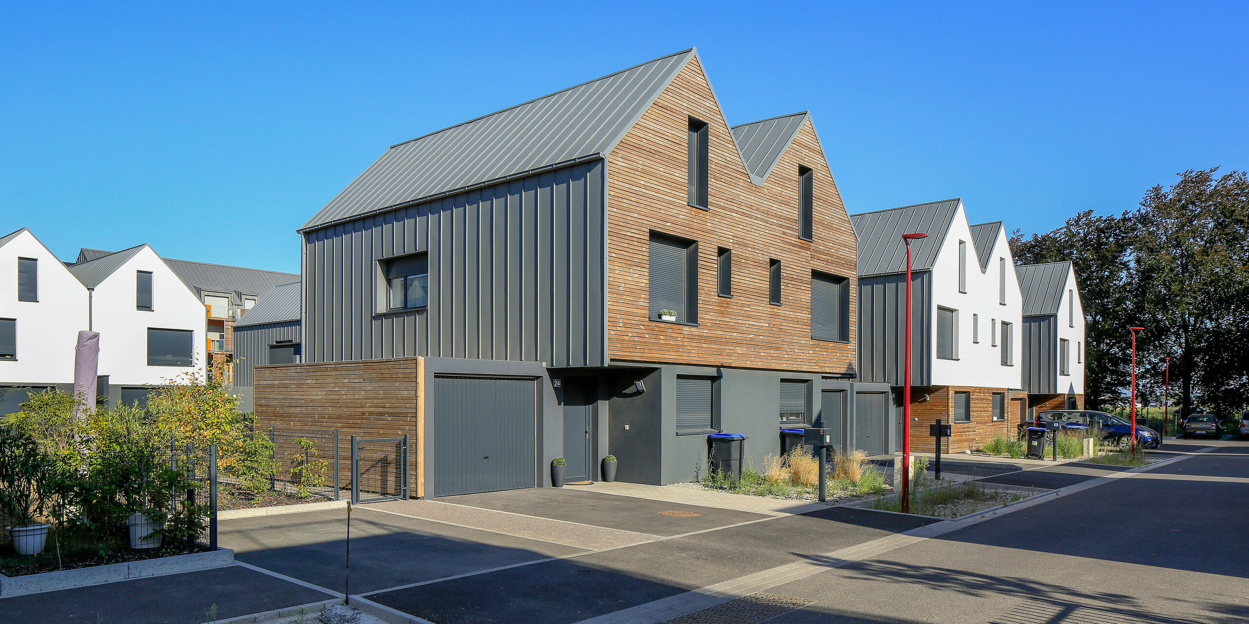 Le joint debout PREFALZ en gris souris s'étend sur les façades et les toits à pignon d'un lotissement mitoyen à Mundolsheim. Les coques uniformes du bâtiment en aluminium créent une image globale harmonieuse.