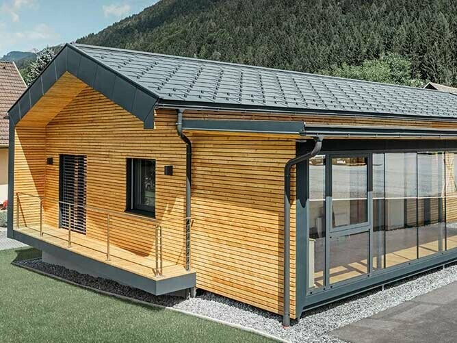 Neues Bürohaus der Firma Holzbau Faltheiner mit Lärchenholz-Fassade und einem PREFA Dach in anthrazit und großen Glasflächen, das Satteldach hat kaum Dachvorsprung und wirkt sehr modern