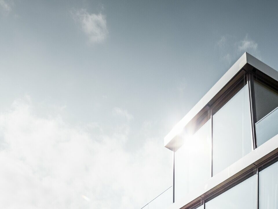 Moderna casa unifamiliare progettata dall'architetto Camenzind; una fascia ricurva collega i livelli, all'esterno l'arco è rivestito con le scaglie PREFA, facili da lavorare, in bianco puro.