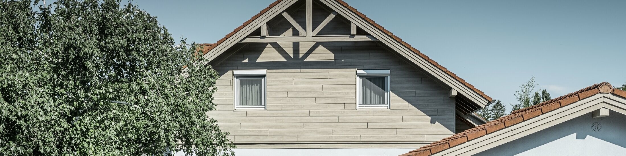 Die Aluminiumfassade in Holzoptik von PREFA wurde hier horizontal verlegt und muss nie mehr nachgestrichen werden.