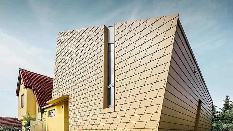 Sehr moderner Zubau eines Einfamilienhauses mit der Alu-Fassade von PREFA; verbaut wurden die PREFA Schindeln in Sandbraun;