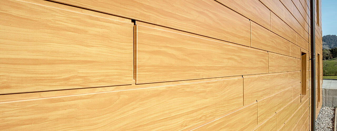 Facciata effetto legno in alluminio - doghe PREFA in rovere naturale, posate orizzontalmente con fuga e giuntura.