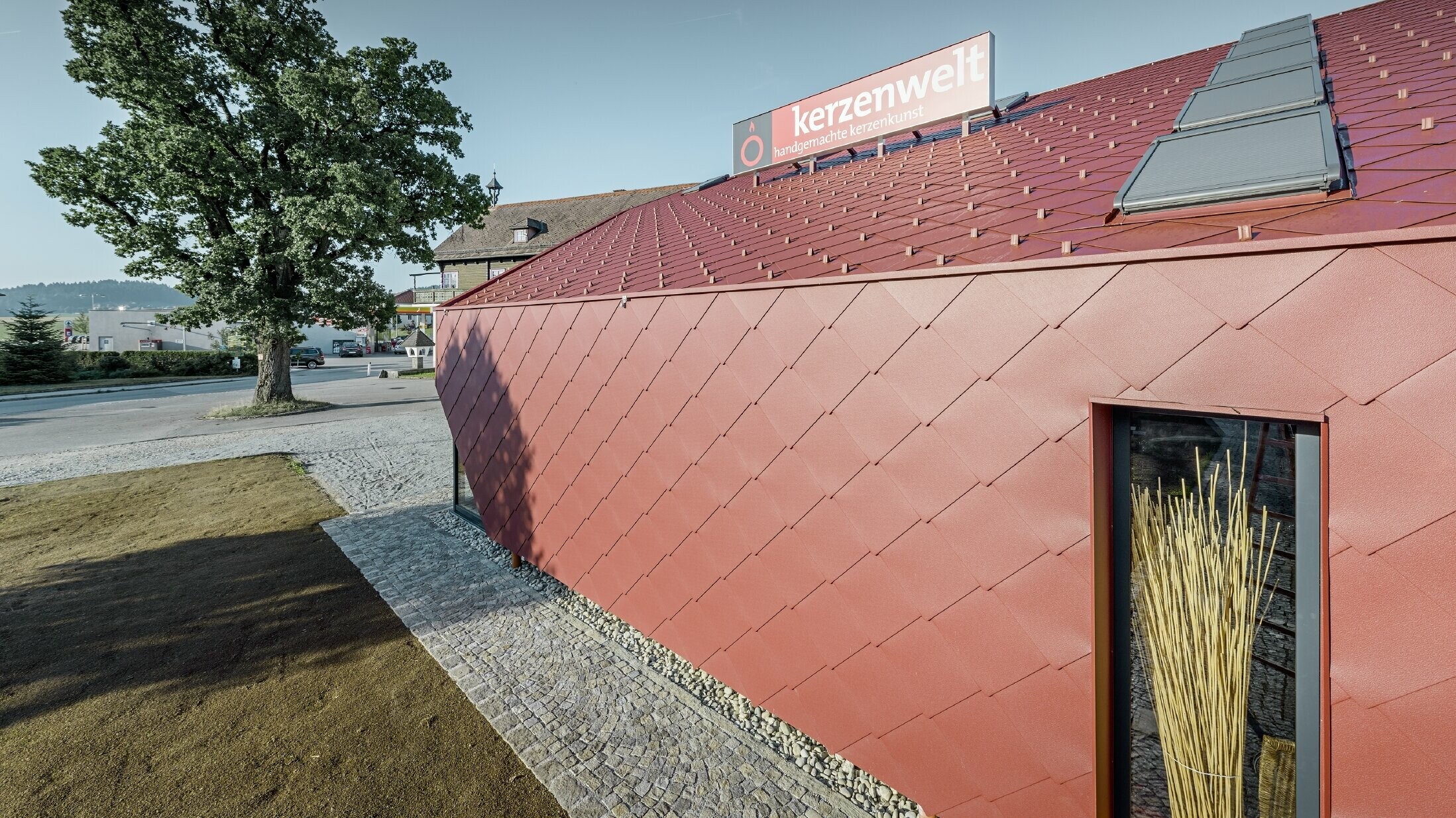 Le Kerzenwelt de Schlägl a été entièrement habillé de losanges PREFA. La couverture de toit et l’habillage de façade ont été réalisés avec le losange 44 × 44 couleur rouge oxyde.