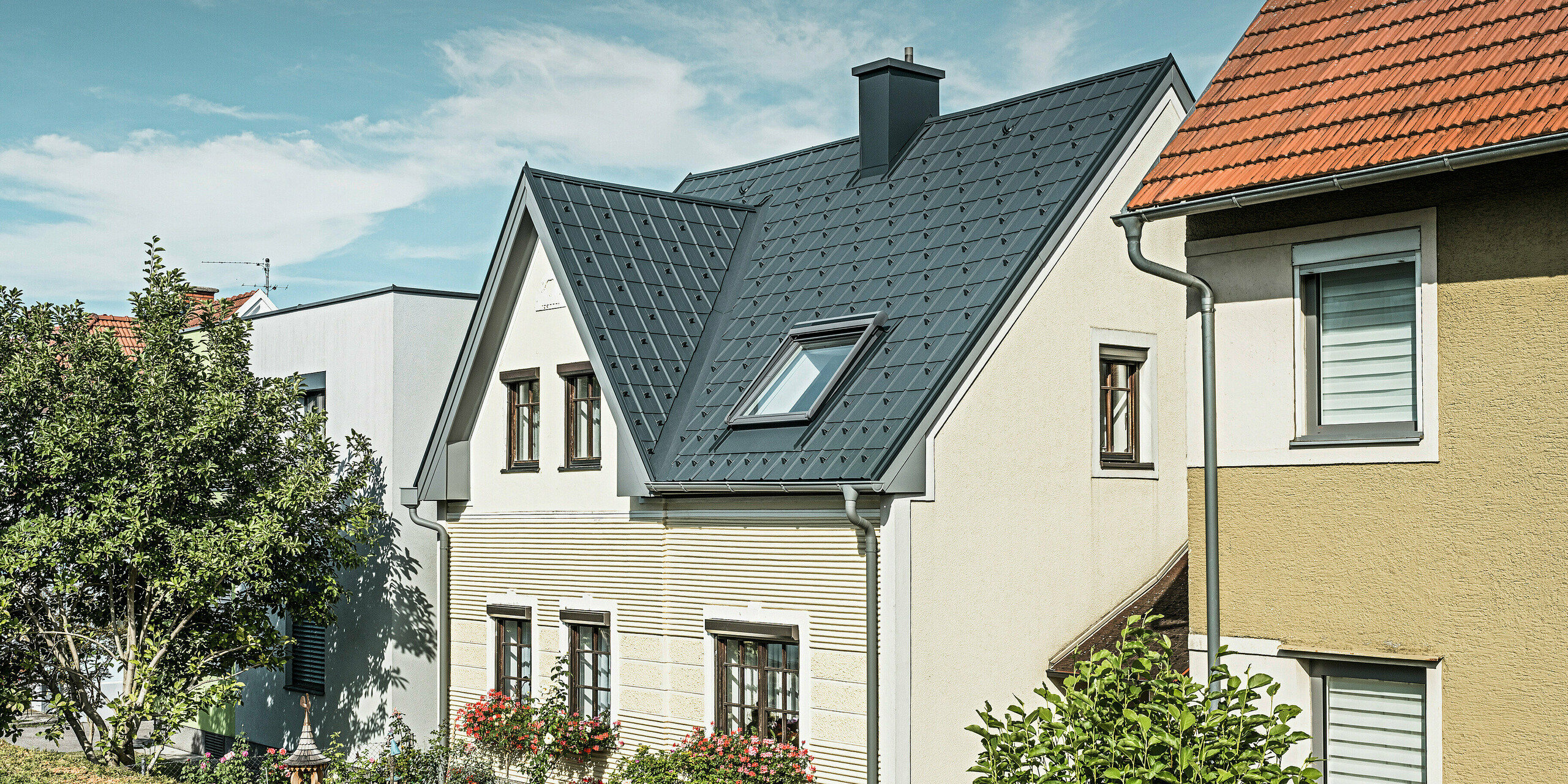 Einfamilienhaus in St. Valentin mit PREFA Dachplatte in anthrazit und einem Dachentwässerungssystem von PREFA in hellgrau