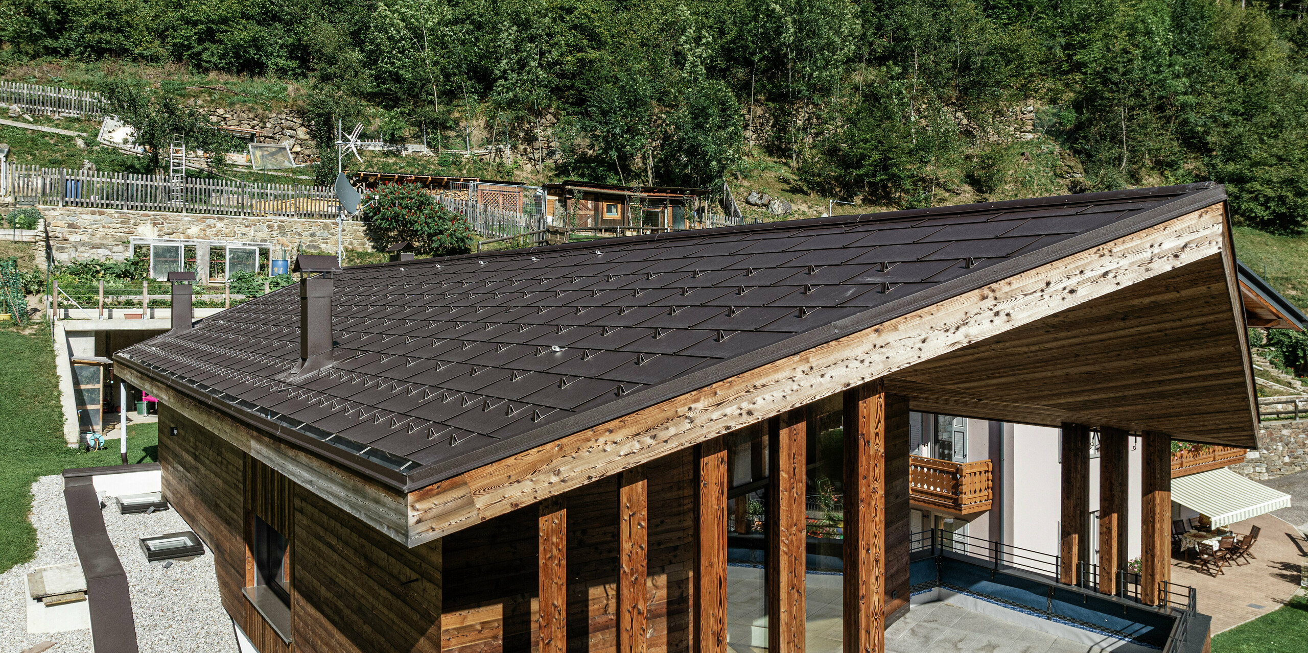 Maison de montagne moderne à Cogolo dans le Val di Sol avec toit en aluminium PREFA durable. Le R.16 PREFA en P.10 brun s'intègre harmonieusement dans l'architecture en bois et offre une protection optimale contre les conditions météorologiques extrêmes. Durable, sans entretien et idéal pour les régions alpines - une interaction parfaite entre design et fonctionnalité.