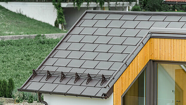 Dachsanierung mit der PREFA Dachplatte R.16 Dach mit der PREFA Dachplatte R.16 in Nussbraun und Schneerechensystem.