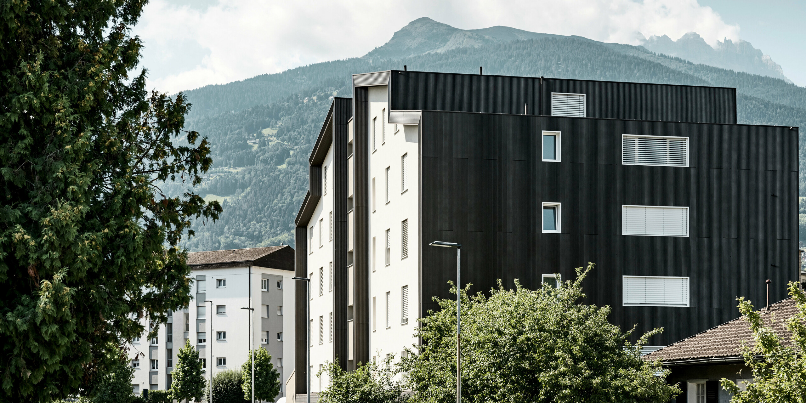 La façade du complexe résidentiel Les Dailles a été largement recouverte de l'impressionnant profil triangle PREFA en bronze. Le toit du bâtiment a été recouvert de PREFALZ en bronze.