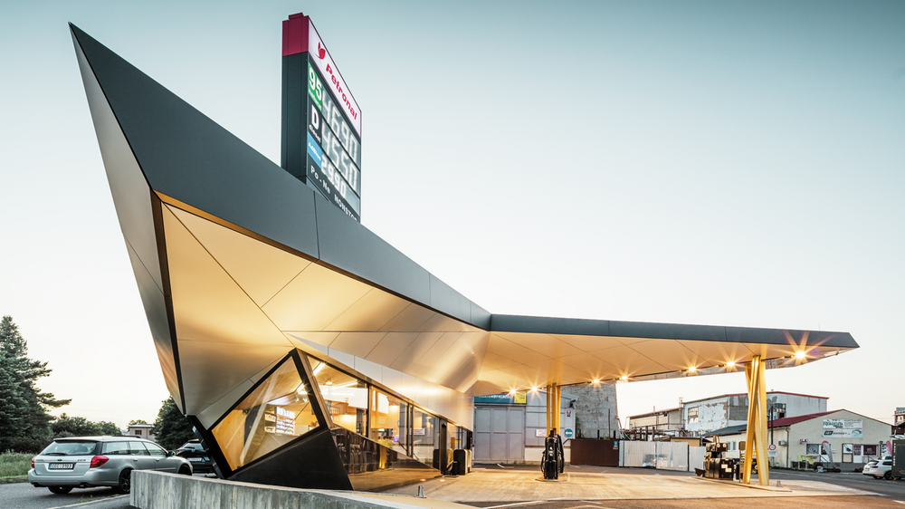 Seitlicher Blick auf die dynamische, mit Aluminium bekleidete Tankstelle von Architekt Daniel Zerzán: Etliche Dreiecke und Trapeze strukturieren die Fassade.