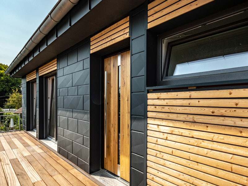 Maison individuelle moderne avec panneaux pour façade Siding.X en anthracite et éléments en bois. 