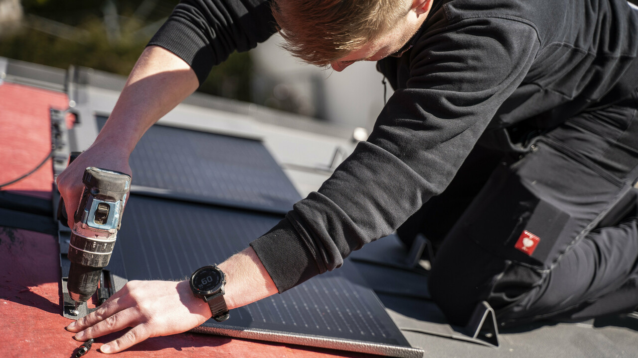 Pose de la tuile solaire par un collaborateur PREFA.