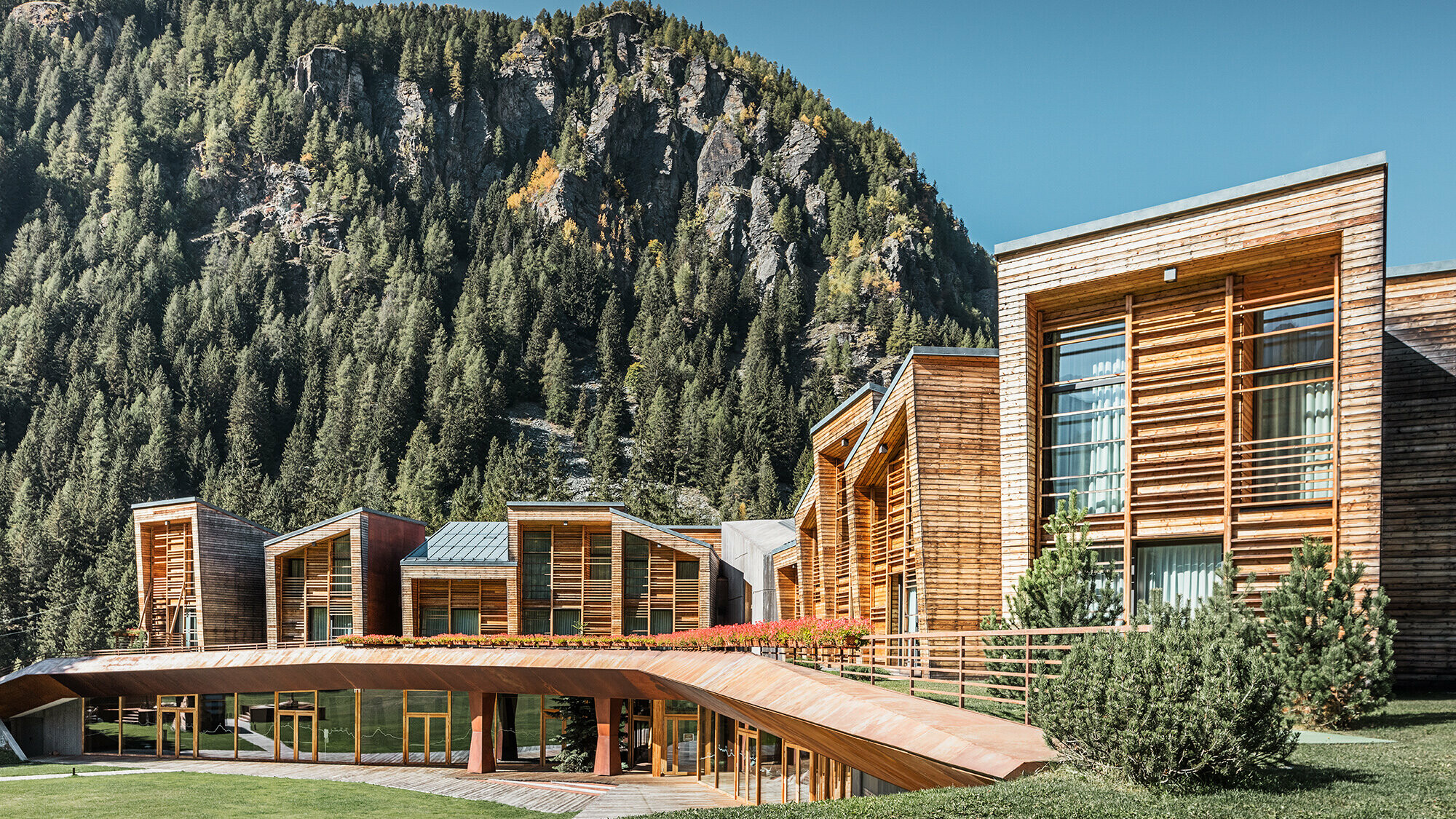 Vue latérale des deux étages du complexe CampZero dans la Vallée d’Aoste, avec les montagnes en arrière-plan.