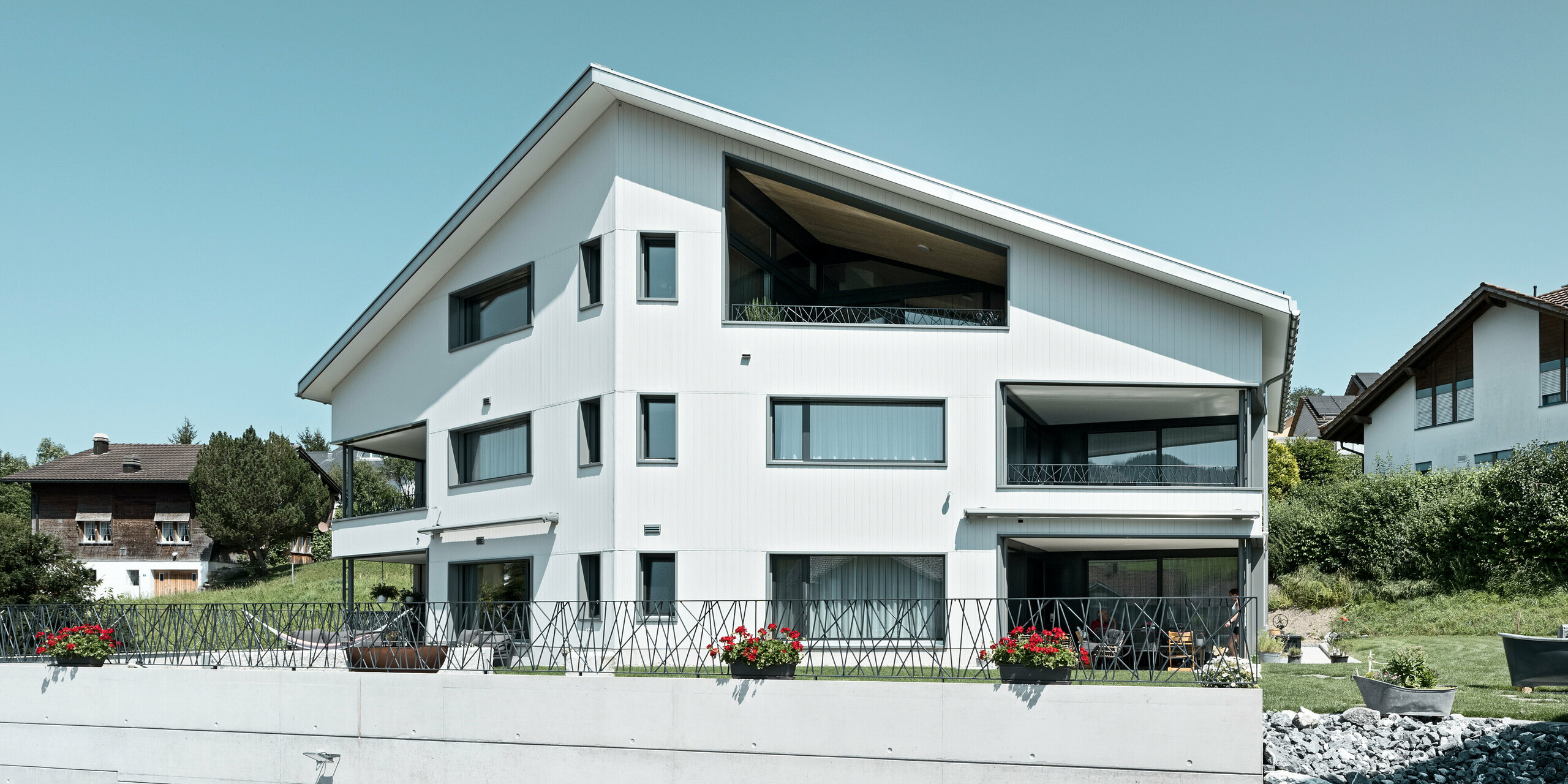 PREFA Sidings in P.10 Steingrau bzw. P.10 Prefaweiß an den Fassaden von zwei benachbarten Mehrfamilienhäusern in Weissbad, Schweiz.