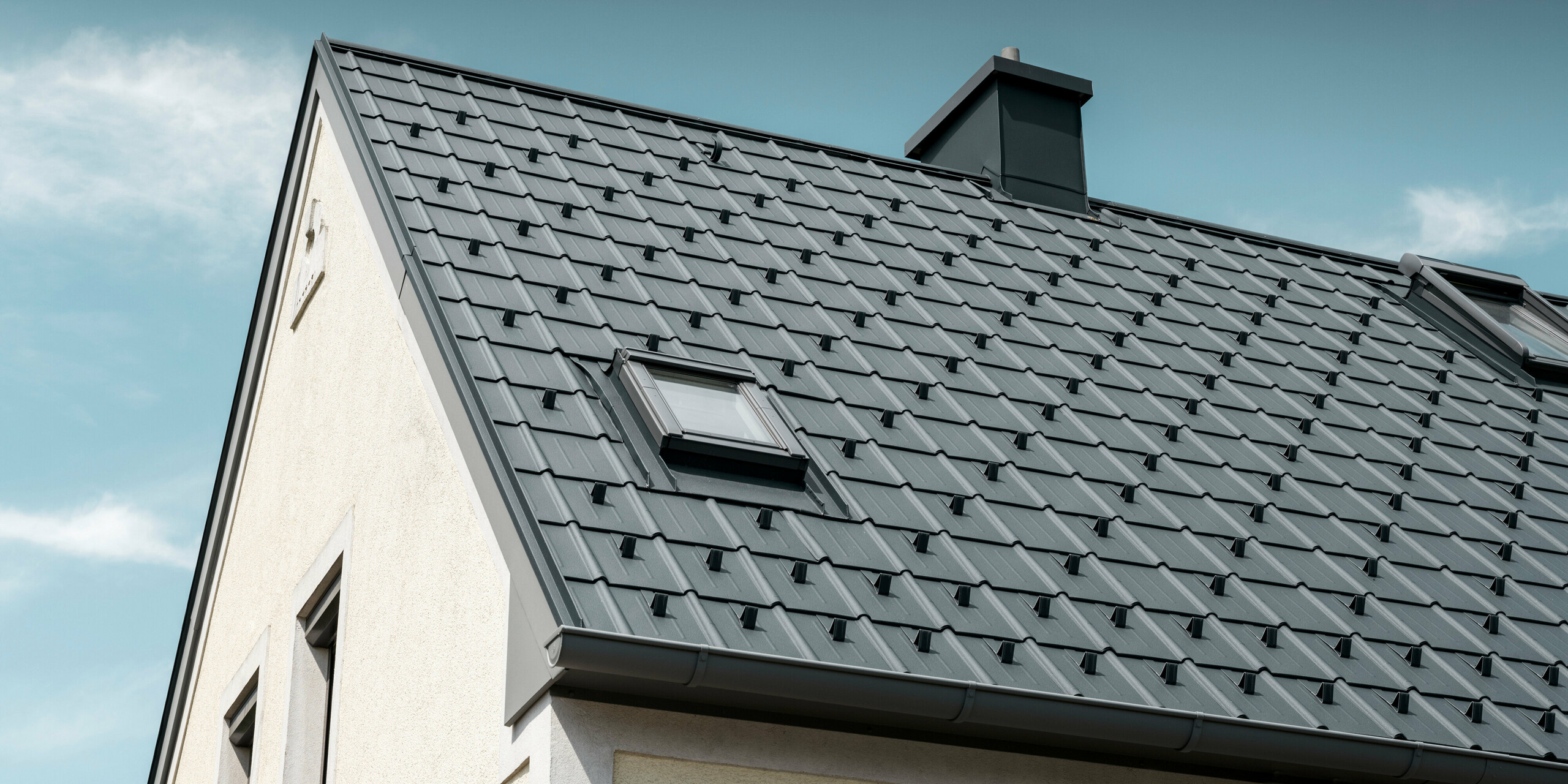 Einfamilienhaus in St. Valentin mit PREFA Dachplatte in anthrazit und einem Dachentwässerungssystem von PREFA in hellgrau