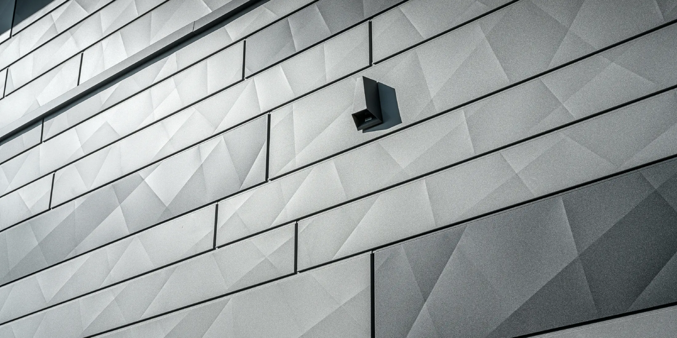 Detailansicht der Siding.X Fassadenpaneele in der Farbe P.10 Hellgrau und Anthrazit.
