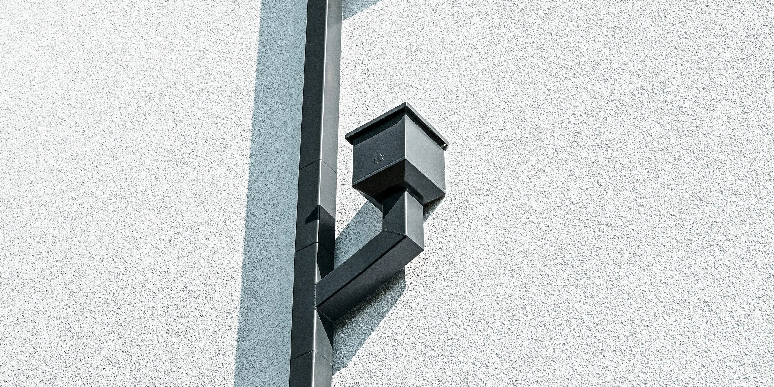 Eine Wohnanlage in Ahnatal, Deutschland wurde mit dem PREFA Dachentwässerungssystem Quadratrohr in P.10 Anthrazit ausgestattet. 