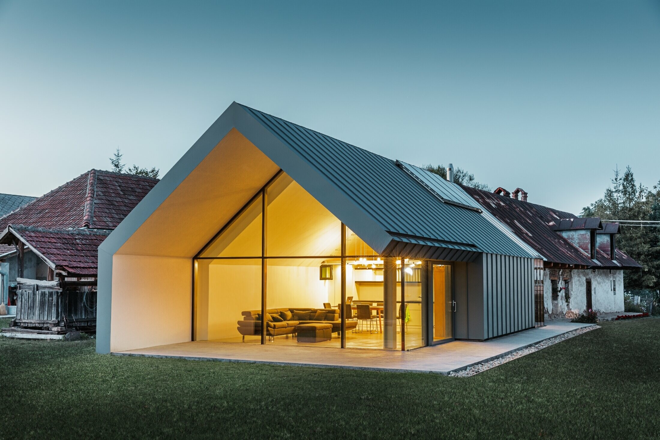 Studio di architettura moderno e casa unifamiliare che accosta una vecchia casa contadina con facciata in pietra, rivestita con aggraffatura e  aggraffatura angolare PREFA in grigio chiaro